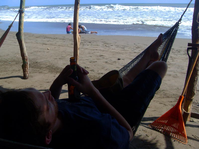Rowan enjoying a beer and hammock with a beach view in La Boquita