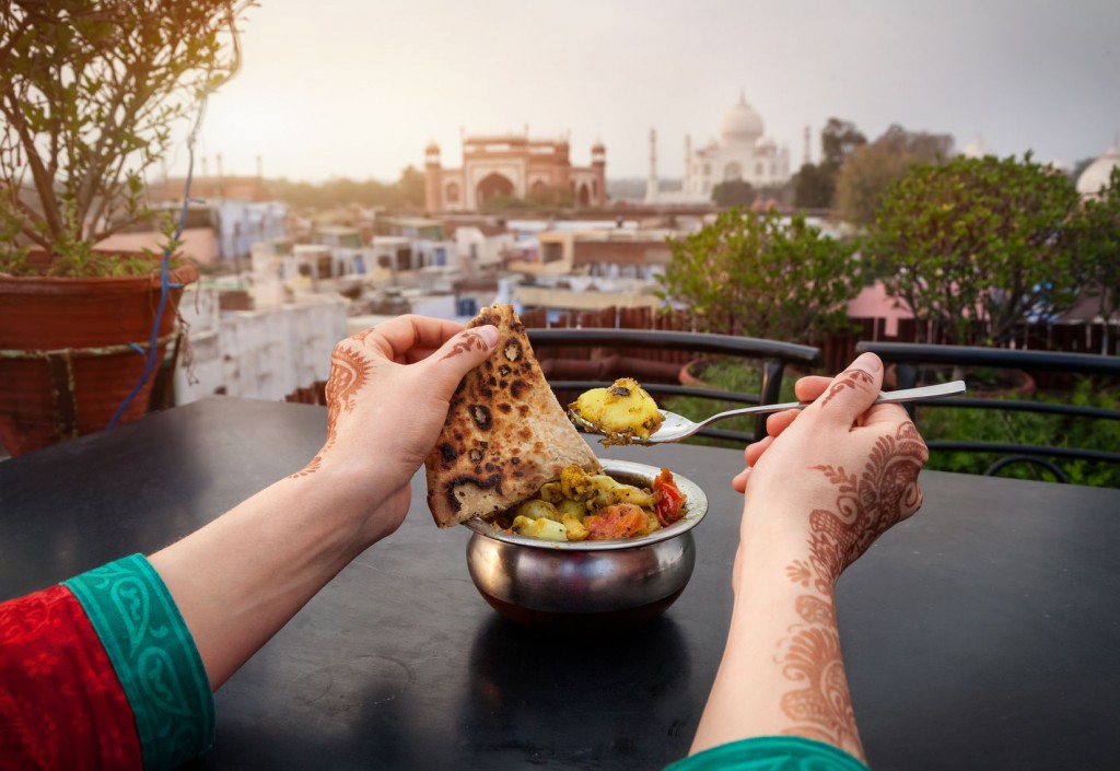 Woman eating Indian food overlooking the Taj Mahal in India
